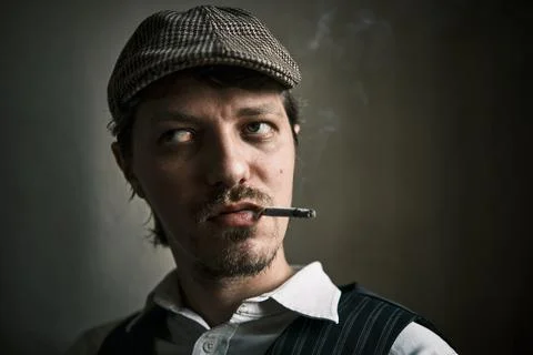 Young guy smoke a cigarette, dressed in a retro style Stock Photos