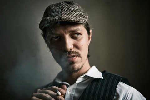 Young guy smoke a cigarette, dressed in a retro style Stock Photos