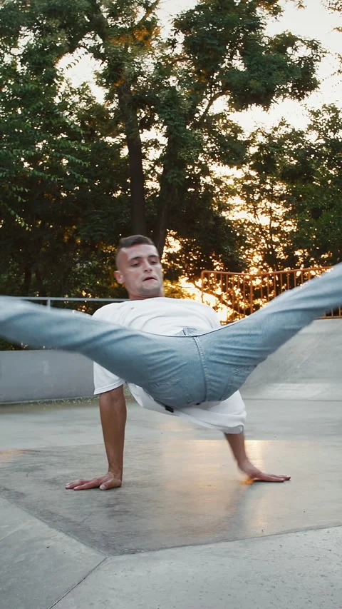 Young guy is spinning performing flare movement while breakdancing on pump track Video stock 314020630
