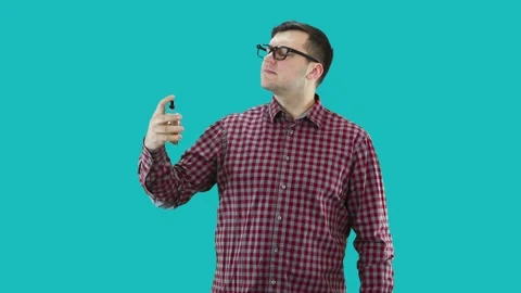 A young guy  splashes perfume on himself. Stock Footage 133185151