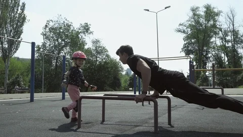 A young guy with a sporty physique doing push-UPS on the Playground, next to him Stock Footage 109165042