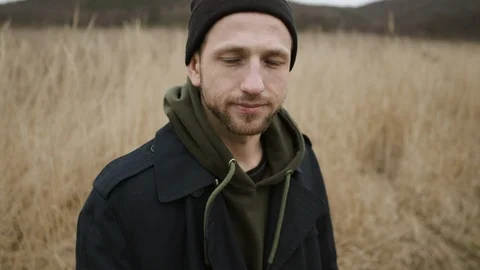 Young Guy Standing In The Field With Dry Grass. Serious Guy With Sadness In His Stock Footage 125509401