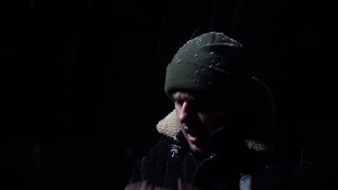 Young guy stands in the cold, snow falls, cold evening Stock Footage 122237350
