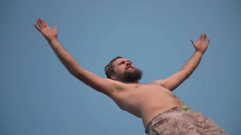 A young guy stands with his hands raised and is actively breathing. Video stock 234020103