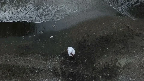 Young guy stands on the shore by the water and wipes himself with a towel Video stock 103808908