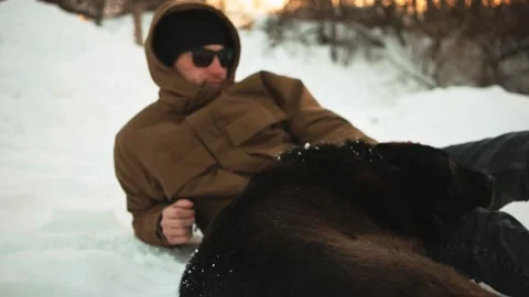 A young guy is stroking his dog. On open air. Winer. Stockbeeldmateriaal 150331516