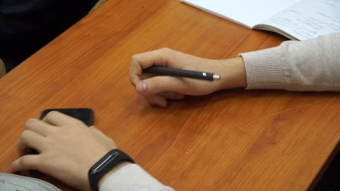 A young guy student bored of sitting at the table. He toils from idleness. Stock Footage 100033433