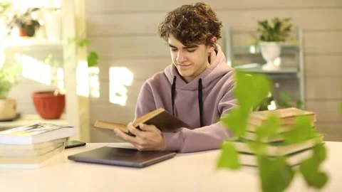 Young guy, student learning lessons at home, reading a book Stock Footage 168813214