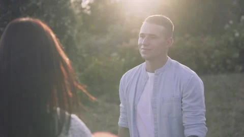 A young guy on a sunset background is walking with a girl Stock Footage 145986034