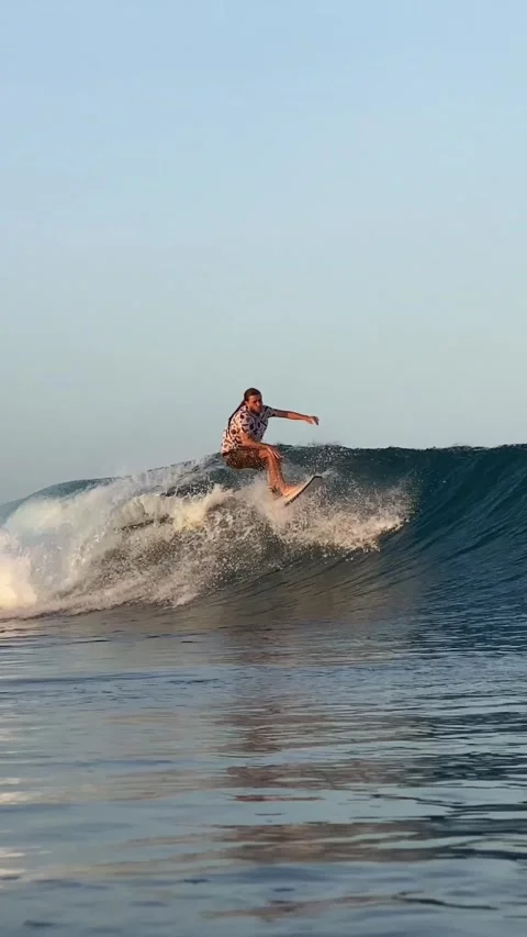 Young guy surfs in the ocean. Vertical video Stock Footage 300749896
