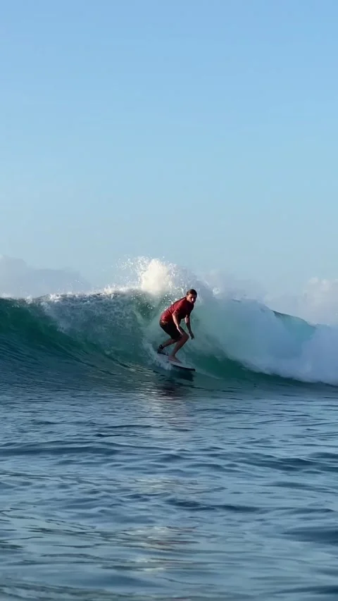 Young guy surfs in the ocean. Vertical video Stock Footage 300749922