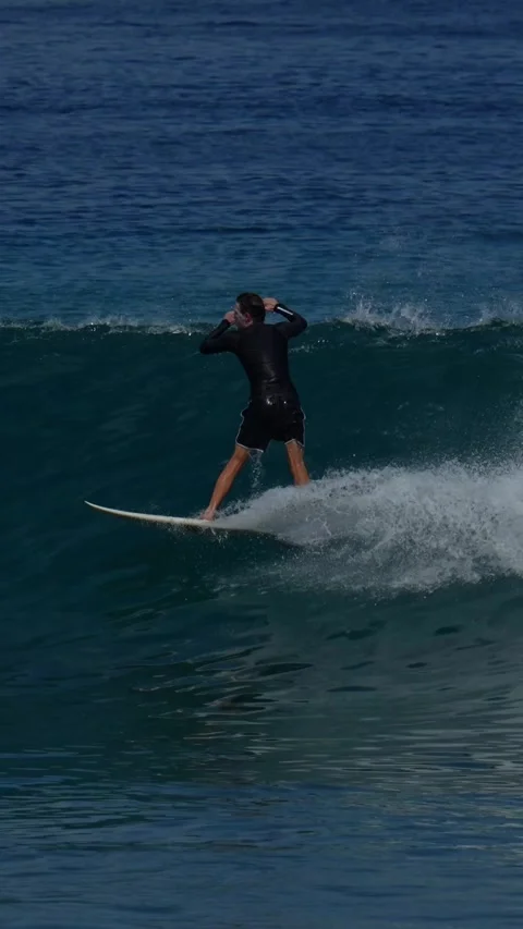Young guy surfs in the ocean.Vertical video Stock Footage 300426092