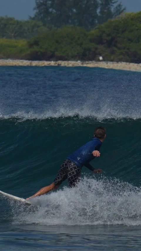 Young guy surfs in the ocean.Vertical video Stock Footage 300426131