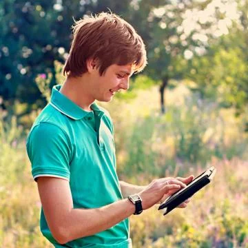 Young guy with a tablet outdoors Stock Photos