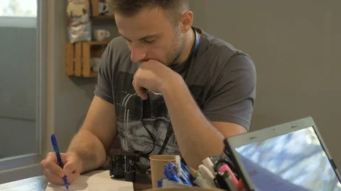 A young guy takes notes on a paper in the workplace. Stock Footage 82305145