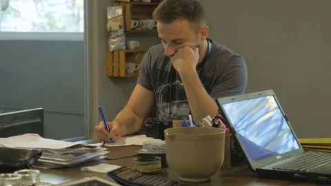 A young guy takes notes on a paper in the workplace. Stock Footage 82305488
