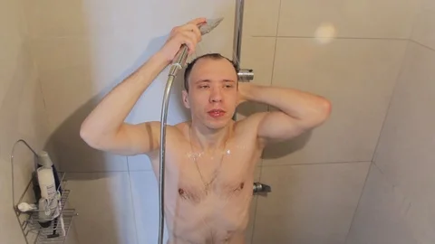 The young guy takes a shower Stock Footage 86353082