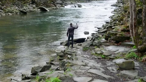 A young guy takes a video of a mountain landscape on a mobile and makes a selfie Video stock 83431659