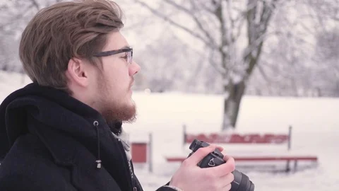 Young guy is taking pictures of a winter day Stock Footage 83370062