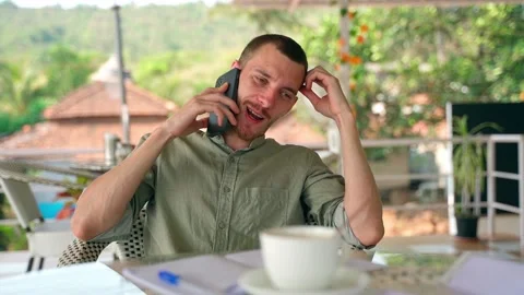 A young guy talking cheerfully and enthusiastically on the phone. Stock Footage 231336823