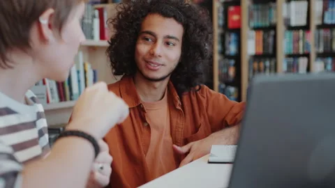 Young Guy Talking with Female Group Mate in Library Stock Footage 277722152