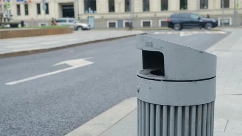 A young guy throws garbage into a trash can on the street. Cleanliness concept. Stock Footage 139883680