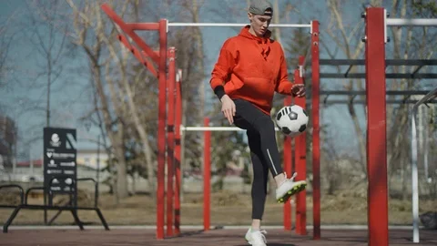 A young guy throws a soccer ball his feet. Street football. Slow motion, 4K Stock Footage 114132946