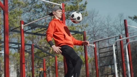 A young guy throws a soccer ball his feet. Street football. Slow motion, 4K Stock Footage 114133044