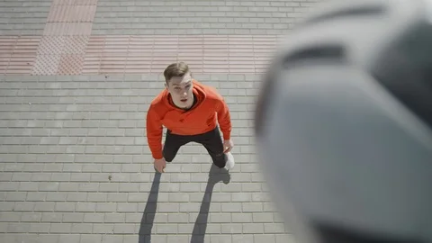 A young guy throws a soccer ball with his feet. Street football. 4K Stock Footage 114133182