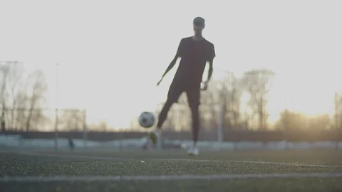 A young guy throws a soccer ball with his feet. Street football. 4K Stock Footage 114133202