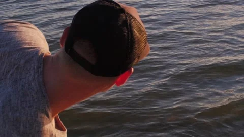 Young guy throws stones on the water.The rock jumps on the water.Entertainment Stock-Footage 140314095