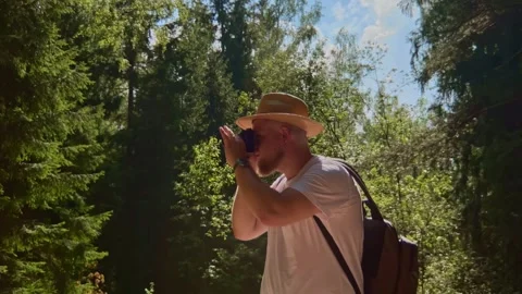 Young guy tourist making content of summer forest from bird watchig Stock Footage 252752475