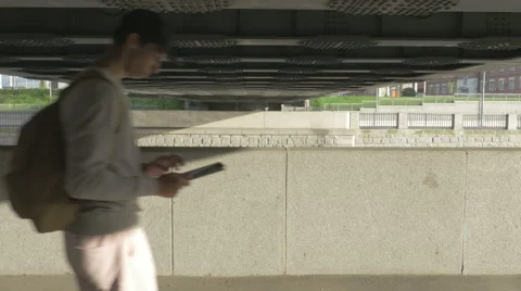 Young guy in town on a skateboard with a tablet in hand in the summer 库存影片 65375068