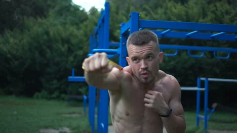 Young guy training in the park with an elastic band Stock Footage 160165333