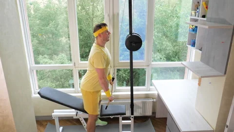A young guy trains his triceps muscle. An athlete with a headband Stock Footage 281375859