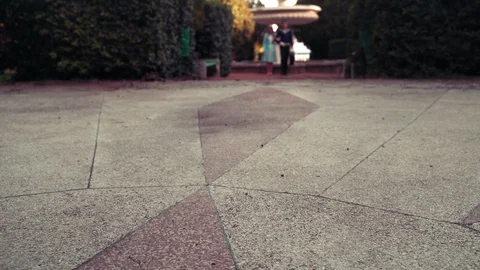 A young guy in uniform and a young girl in a blue dress walk in the park Video stock 129847470