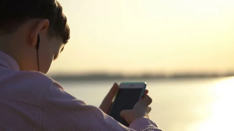 Young guy uses an application on your smartphone or climbs in social networks Stock Footage 75335047