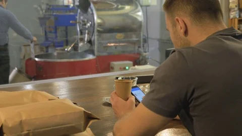 The young guy uses his smartphone in the coffee house. Stock Footage 82305814