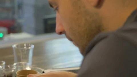 The young guy uses his smartphone in the coffee house. Stock Footage 82306491