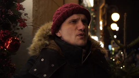 Young guy using smartphone on a urban street in evening standing near storefront Stock Footage 83917352