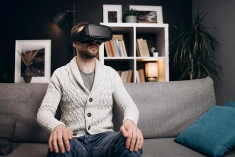 Young guy using VR headset during leisure time Stock Photos
