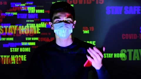 Young guy using wet wipe and sanitizer to clean cell phone screen. Man with mask Video stock 130249718