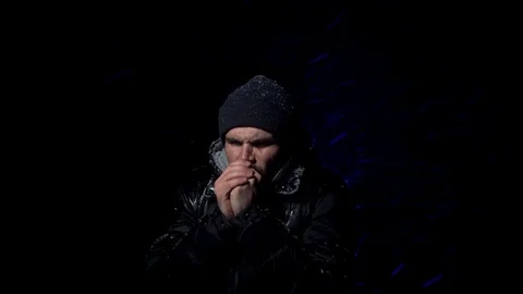 The young guy is very cold in his hands and trying to get a little warm Stock Footage 122296073