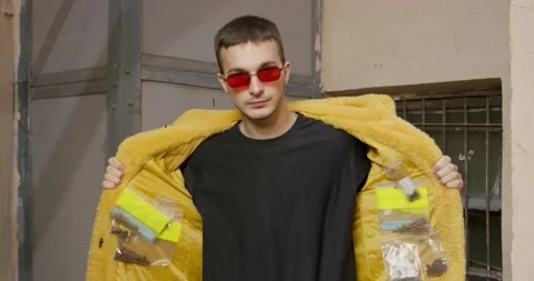 A young guy in a vibrant yellow fur coat and red glasses confidently opens his Stock Footage 242053565