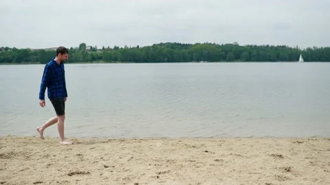 Young guy walking on the beach Stock Footage 196148262