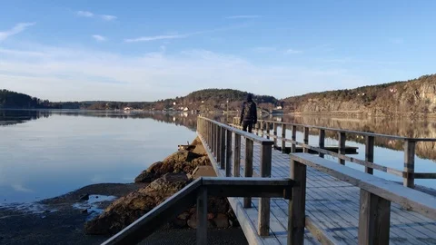 Young Guy Walking on a Jetty a Winter Day Stock Footage 99933062