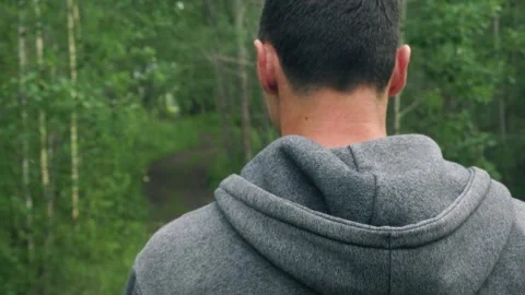 A young guy is walking in the woods. A view from the back. Close-up Stock Footage 260554739