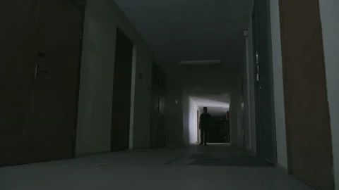 A young guy walks along a dark corridor 库存影片 155905577