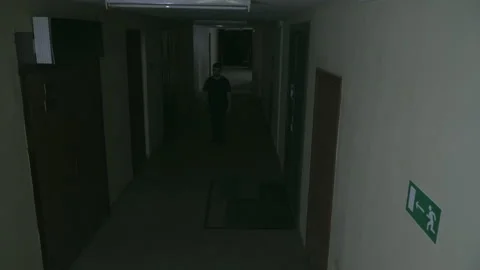 A young guy walks along a dark corridor 库存影片 155905669