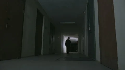 A young guy walks along a dark corridor 库存影片 155905716